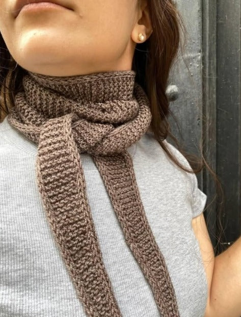 Brown hand-knit garter stitch scarf tied loosely around the neck